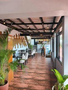 a dining room with tables and chairs and plants at Speranza Hotel & Restaurant in Infanta +14 photos