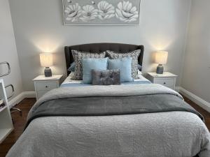 a bedroom with a large bed with two night stands at Daisy Cottage on Duke 2BR in Yarram