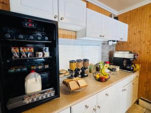 a kitchen with white cabinets and a black refrigerator at Silver crest lodge in Grande Prairie