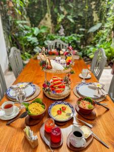 a wooden table with plates of food on it at Villa Sarakkuwa in Pamunugama