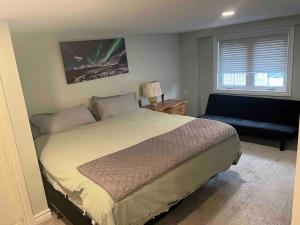 a bedroom with a bed and a couch and a window at Cozy cottage on the River in Port Dover +16 photos