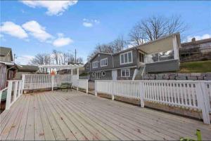 a house with a white fence and a wooden deck at Cozy cottage on the River in Port Dover