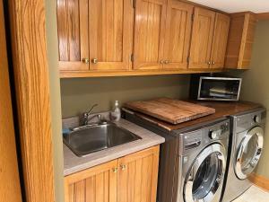 a kitchen with a sink and a washing machine at Cozy cottage on the River in Port Dover