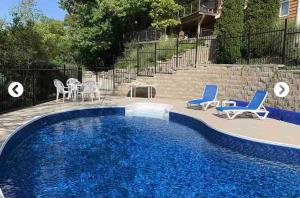 a swimming pool with blue chairs and a table and chairs at Cozy cottage on the River in Port Dover