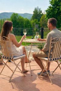a man and woman sitting at a table with wine glasses at The Meetinka - Peaceful Stay, Jeseníky in Jeseník