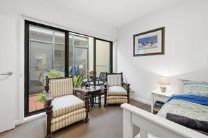 a bedroom with a bed and a table and chairs at Tide & Town - Perfectly Located! in Inverloch