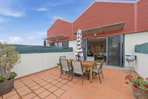 a house with a table and chairs on a patio at Tide & Town - Perfectly Located! in Inverloch