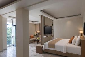a hotel room with a bed and a television at Hotel & Resto Marza 88 in Pangkajene