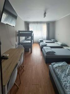 a room with nine beds and a table and a desk at Żeromskiego 2024 in Gdynia