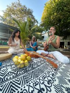 a group of people sitting around a table with fruit at Mantra Homestay in Bacalar