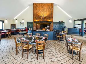 a restaurant with tables and chairs and a fireplace at ibis Saint Dizier in Saint-Dizier