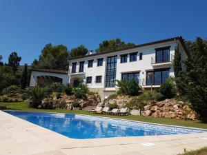 a house with a swimming pool in front of it at Villa Pantanal in Golf Costa Brava in Santa Cristina d'Aro