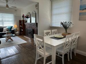 a dining room with a white table and chairs at Daisy Cottage on Duke 2BR in Yarram +11 photos