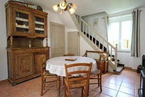 a dining room with a table and chairs and a staircase at Les soleils in Nedde