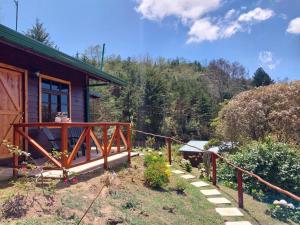 a house with a porch and a garden in front of it at Curuba Lodge in El Copey