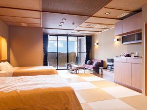 a hotel room with two beds and a living room at Manten no Yado in Gujo
