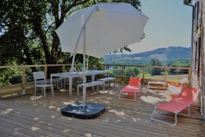 a table and chairs with an umbrella on a deck at Mazeau nicot in Nedde