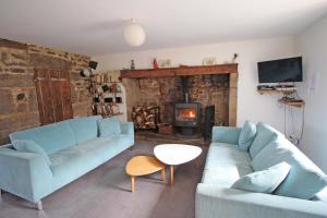 a living room with a blue couch and a fireplace at Mazeau nicot in Nedde