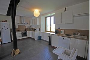 a large kitchen with white cabinets and a sink at Mazeau nicot in Nedde