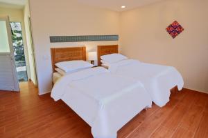 two beds in a room with white sheets at SERENA ALTIT FORT RESIDENCE in Hunza Valley