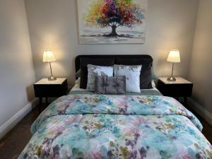 a bedroom with a large bed with two lamps at Daisy Cottage on Duke 3BR in Yarram