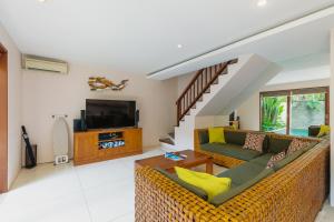 a living room with a couch and a tv at Du Ciel Villa by Betterplace in Canggu