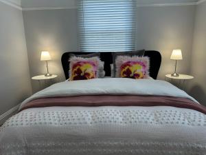 a bedroom with a large bed with two lamps at Daisy Cottage on Duke 3BR in Yarram