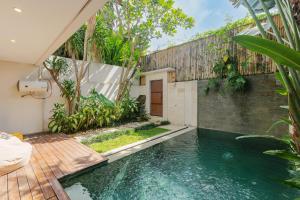 a swimming pool in the middle of a house at Du Ciel Villa by Betterplace in Canggu +19 photos