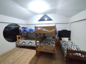 a room with two bunk beds and a ceiling at Sumaq Illary Bonito Amanecer in Urubamba