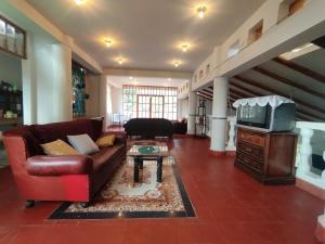a living room with a couch and a tv at Sumaq Illary Bonito Amanecer in Urubamba