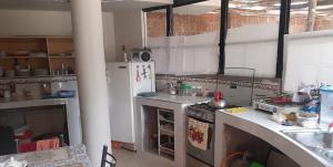 a kitchen with a stove and a refrigerator at Sumaq Illary Bonito Amanecer in Urubamba
