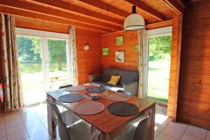 a dining room with a table and a couch at Gîte 87G5511 in Sussac