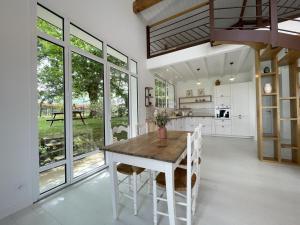 a kitchen with a wooden table and some windows at Hartzurienea in Anhaux