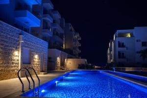 a swimming pool at night with buildings at Bella Vista Residence with private Free Parking in Baošići