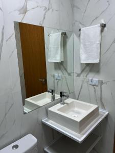 a white bathroom with a sink and a mirror at Hotel Blox Sorriso in Sorriso