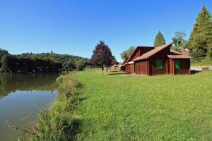 a building on a field next to a river at Gîte 87G5513 in Sussac