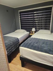 a bedroom with two beds and a window with blinds at Tiny por trabajo in Trinidad
