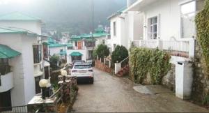 a car parked in a parking lot next to houses at Pine Galaxy in Bhowāli