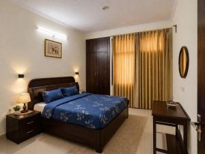 a bedroom with a blue bed and a desk and a window at Pine Galaxy in Bhowāli