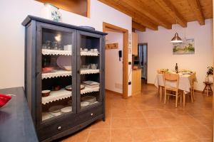 a kitchen and dining room with a cabinet filled with dishes at Appartamento Centro Storico Riva - Happy Rentals in Riva del Garda