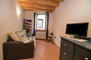 a living room with a tv and a couch at Appartamento Centro Storico Riva - Happy Rentals in Riva del Garda