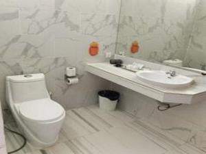 a white bathroom with a toilet and a sink at ThmorDa Resort in Koh Rong Sanloem