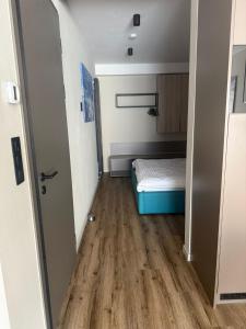 a small room with a bed and a wooden floor at Avenue Chalet in Špindlerův Mlýn
