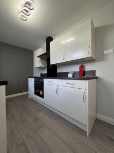 a kitchen with white cabinets and a stove at Stylish double room in Mansfield