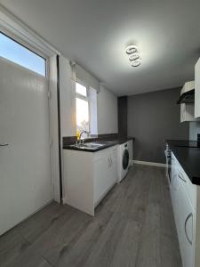 a kitchen with a sink and a washing machine at Stylish double room in Mansfield +4 photos