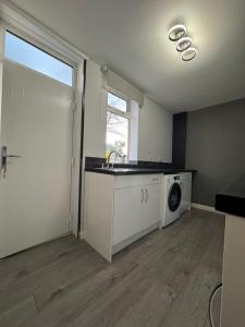 a kitchen with a washing machine and a sink at Stylish double room in Mansfield