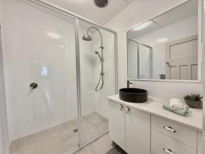a white bathroom with a shower and a sink at 72 Cobra Street House in Dubbo +8 photos