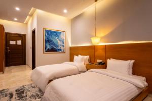 two beds in a hotel room with two beds sidx sidx sidx at Hotel One Gujranwala in Kot Mergulla