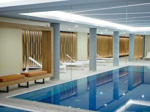 a swimming pool with chairs and tables in a building at Novotel München City in Munich
