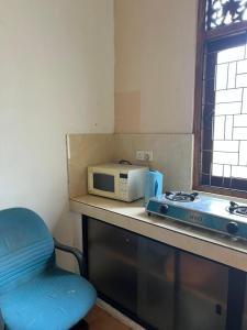 a kitchen counter with a microwave and a blue chair at Villa 87 in Katunayaka +13 photos